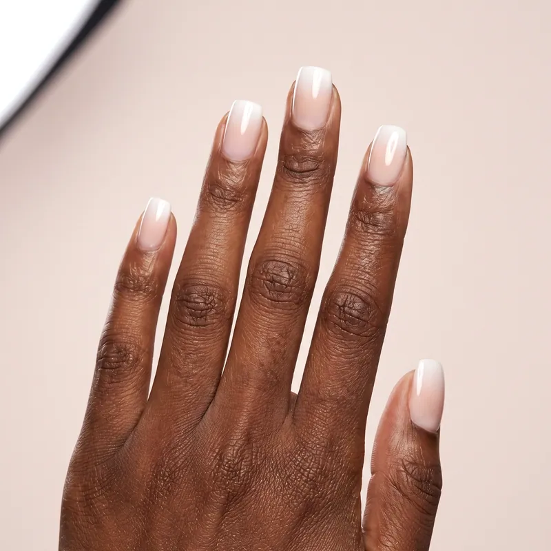 Uñas cuadradas medianas en degradado baby boomer de nude a blanco con acabado muy brillante